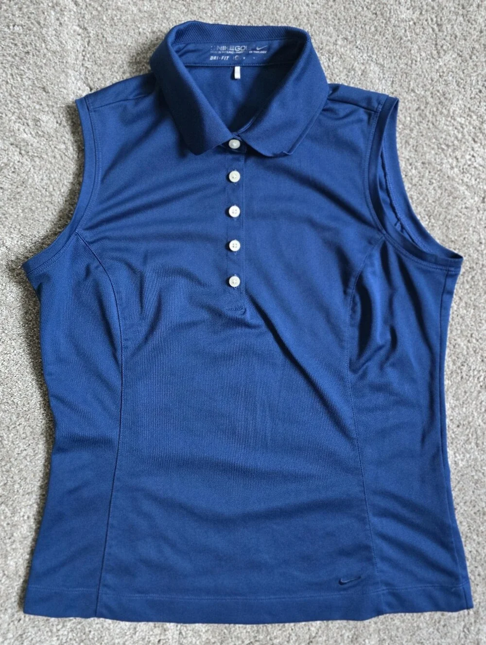Royal blue sleeveless Nike Golf polo featuring a white-buttone